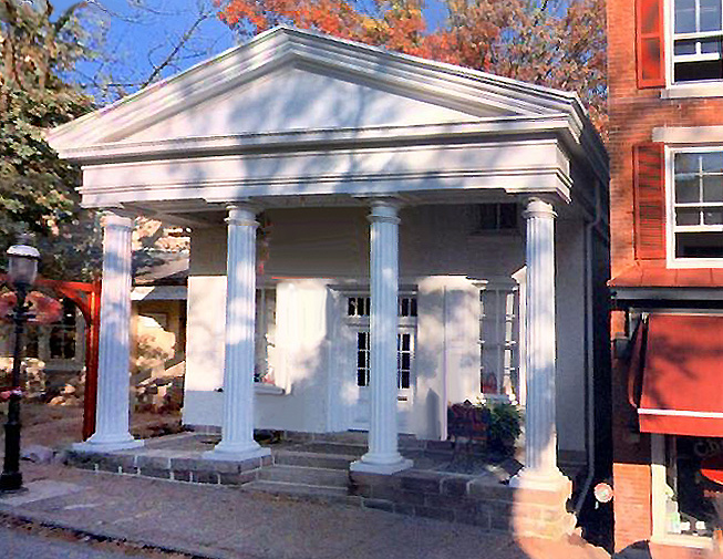 Sidewalk view showing buiding facade of 21 North Main St from opposite side of street